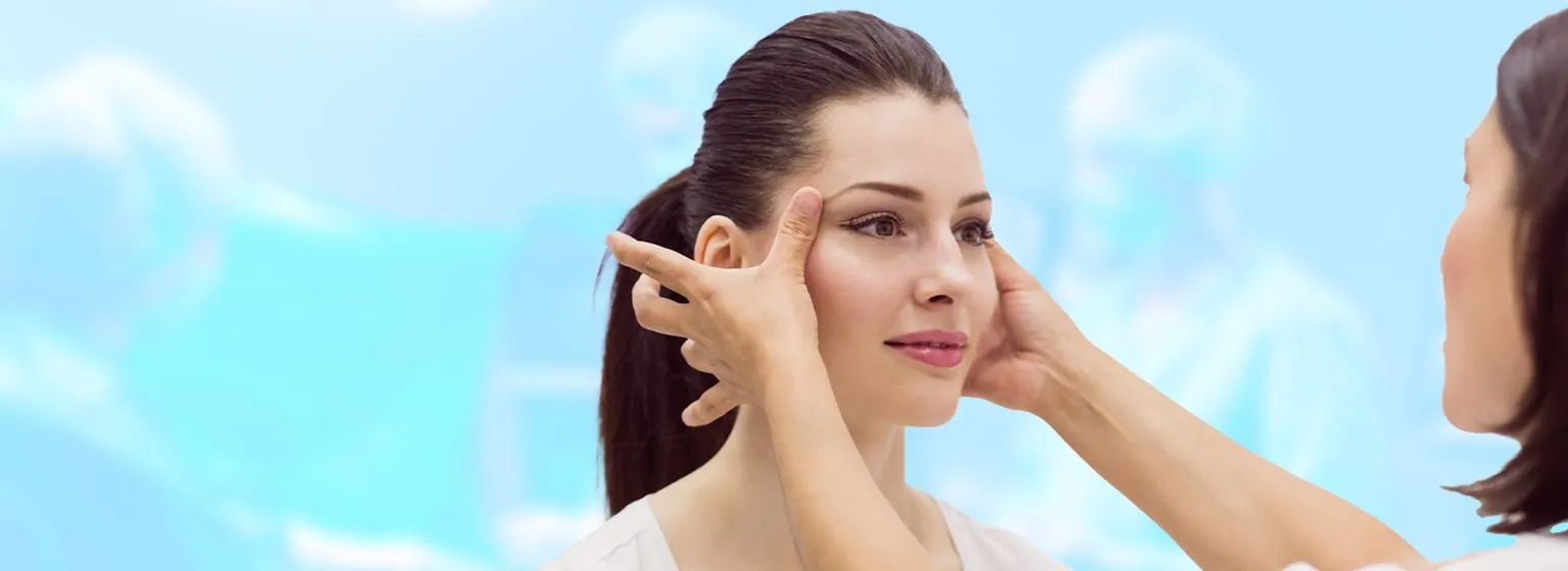 A woman's face being examined by a doctor